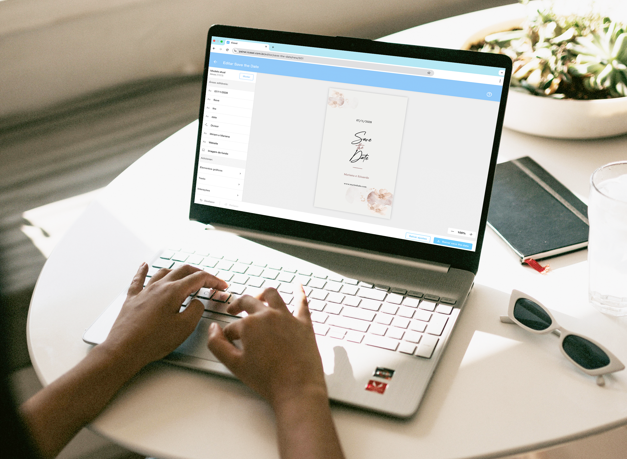 Tela mostrando uma pessoa utilizando o novo Editor de convites do iCasei, em um notebook, que está sobre uma mesa